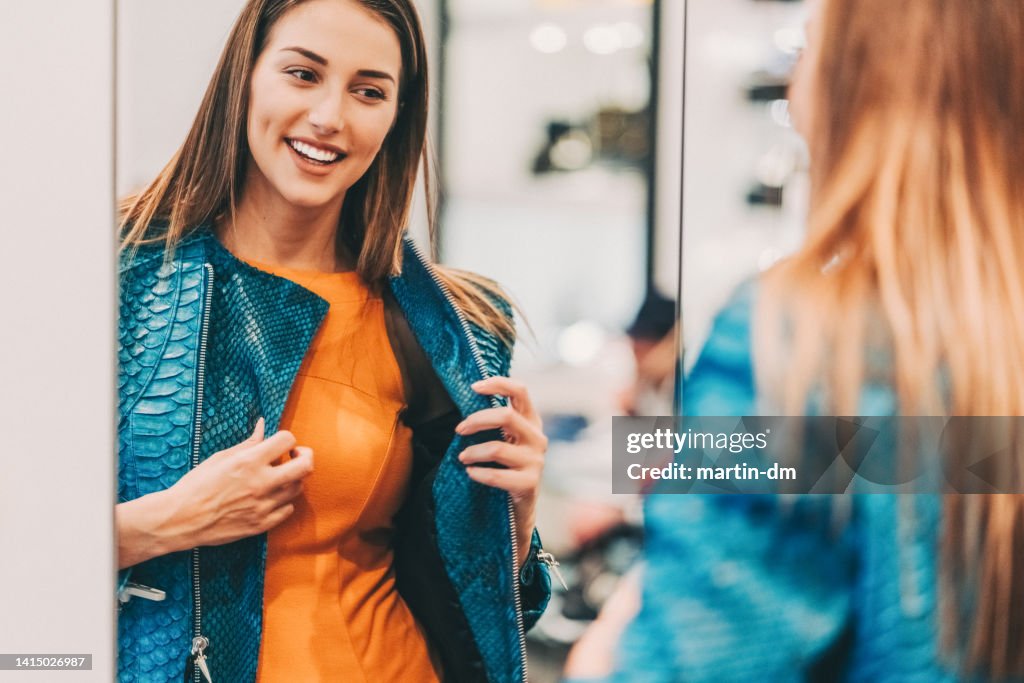 Young woman in the shopping mall enjoying a leather jacket