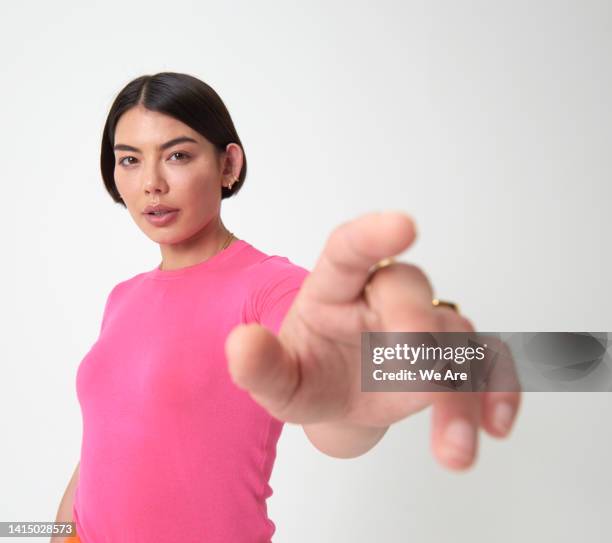 woman reaching hand out toward camera - reaching fotografías e imágenes de stock
