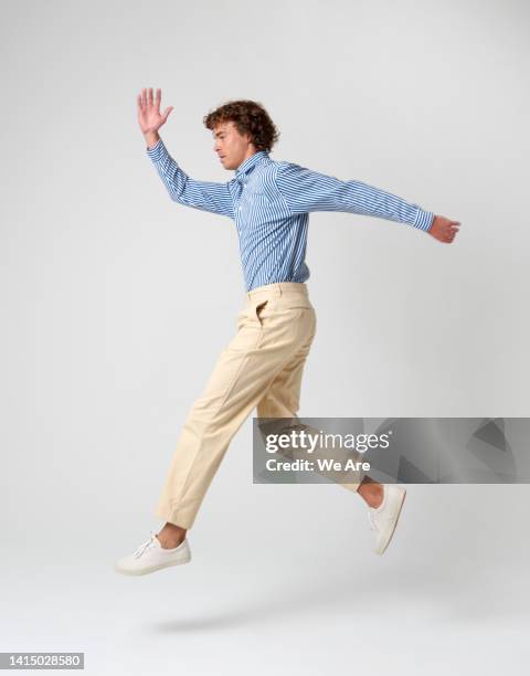 well dressed man leaping - running midair stock pictures, royalty-free photos & images