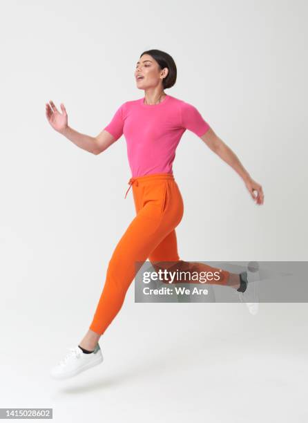 woman running - person jumping stock-fotos und bilder