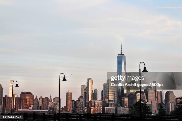 view of buildings in city against cloudy sky,jersey city,new jersey,united states,usa - jersey city stock-fotos und bilder