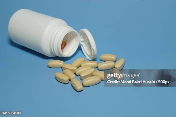 pills with container isolated on blue background,kuala lumpur,malaysia - mohd bakri husain bildbanksfoton och bilder