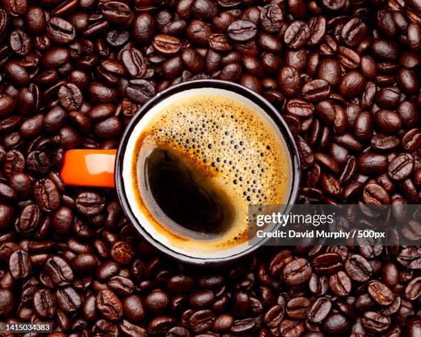 directly above shot of coffee cup with beans on table - arabica coffee drink stock pictures, royalty-free photos & images