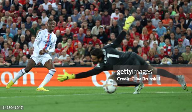 Wilfried Zaha of Crystal Palace scores their team's first goal past Alisson Becker of Liverpool during the Premier League match between Liverpool FC...