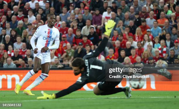 Wilfried Zaha of Crystal Palace scores their team's first goal past Alisson Becker of Liverpool during the Premier League match between Liverpool FC...