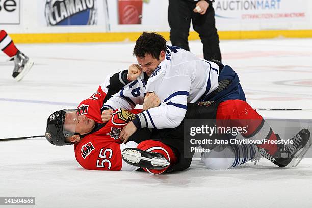 Sergei Gonchar of the Ottawa Senators falls to the ice in a fight against Clarke MacArthur of the Toronto Maple Leafs during an NHL game at...