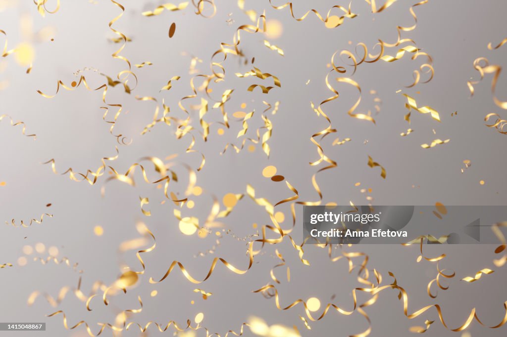 Many falling golden serpentine confetti on gray background. Festive Christmas backdrop. Three dimensional illustration