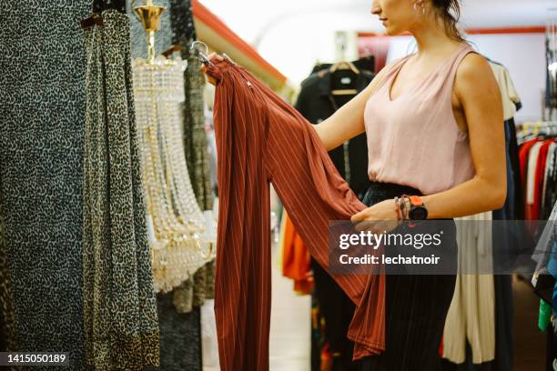 trying out clothes in a vintage shop - second hand sale stock pictures, royalty-free photos & images