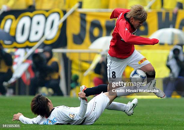 Yosuke Kashiwagi of Urawa Red Diamonds is tackled by Akimi Barata of Kashiwa Reysol during the J.League match between Urawa Red Diamonds and Kashiwa...