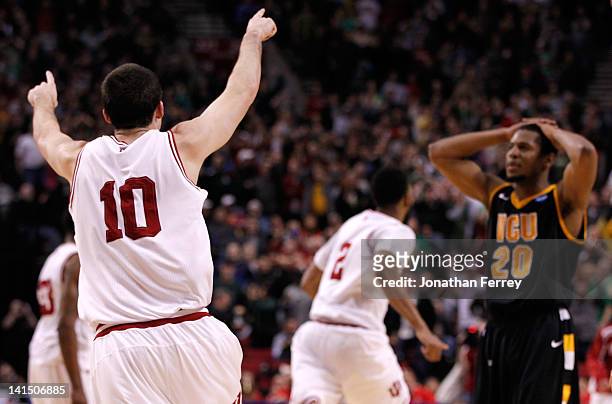 Will Sheehey and Christian Watford of the Indiana Hoosiers celebrates as Bradford Burgess of the Virginia Commonwealth Rams reacts after losing to...