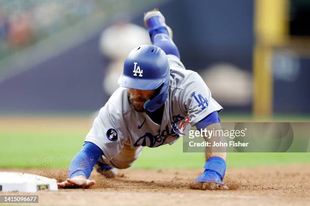 Chris Taylor of the Los Angeles Dodgers dives back to first base in the eighth inning against the Milwaukee Brewers at American Family Field on...