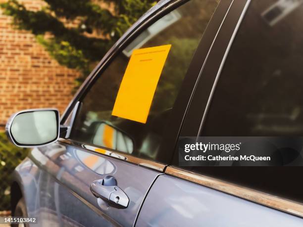 wheel clamp: bright orange immobilization notice sticker on parked car - department of motor vehicles stock pictures, royalty-free photos & images