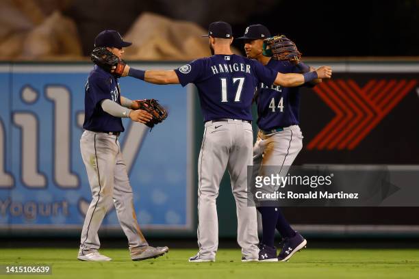 Sam Haggerty, Mitch Haniger and Julio Rodriguez of the Seattle Mariners celebrate a 6-2 win against the Los Angeles Angels at Angel Stadium of...