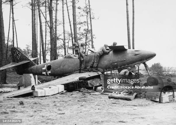 Soldiers from the United States Seventh Army examine a captured damaged Luftwaffe Messerschmitt Me 262 A-1a Jabo twin engined jet-powered fighter...