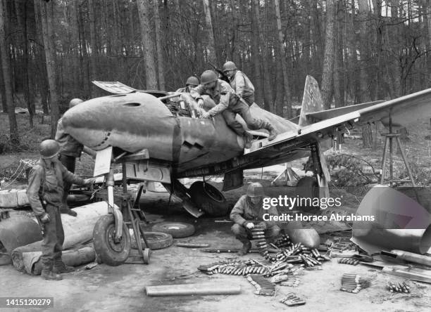 Soldiers from the United States Seventh Army examine a captured damaged Luftwaffe Messerschmitt Me 262 A-1a Jabo twin engined jet-powered fighter...