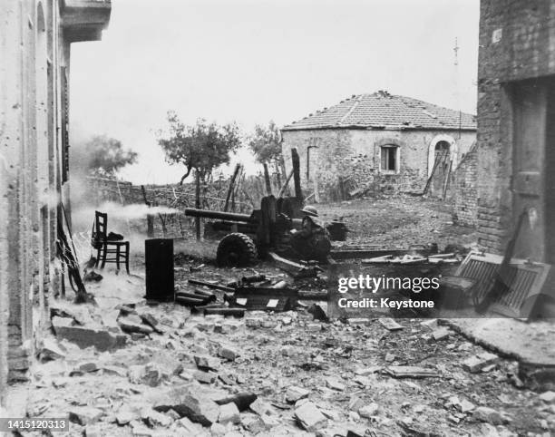 Canadian gunner from the Loyal Edmonton Regiment Anti-Tank Battery of the 1st Canadian Infantry Division fires a 6-pounder QF anti-tank gun against...