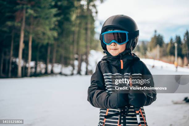 lächelnder süßer junge beim skifahren. - skijacke stock-fotos und bilder