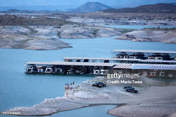 People gather along what was once lakebed, with a 'bathtub ring' of mineral deposits left by higher water levels visible, at the drought-stricken...