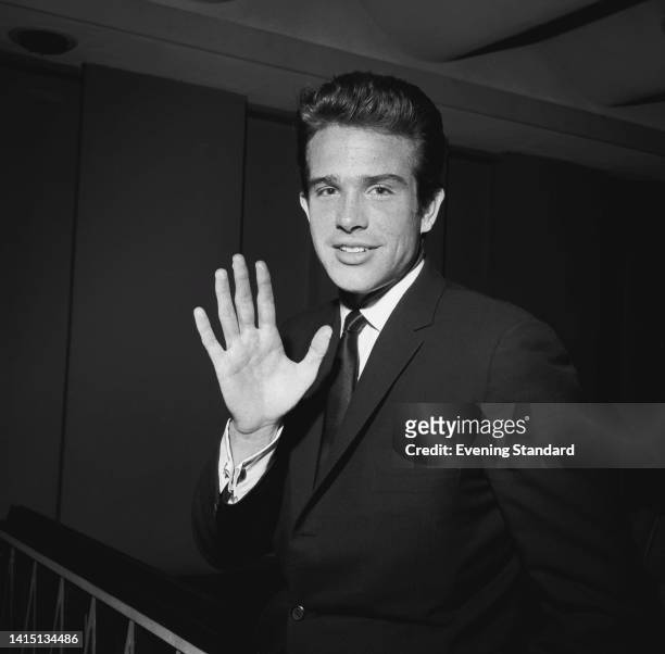 American actor Warren Beatty, wearing a suit with a white shirt and tie, waving as he attends an event in London, England, 17th May 1962.