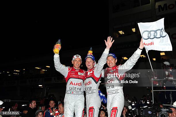 Dindo Capello of Italy, Allan McNish of Scotland, and Tom Kristensen of Denmark, drivers of the Audi Sport Team Joest Audi R18, celebrate their...