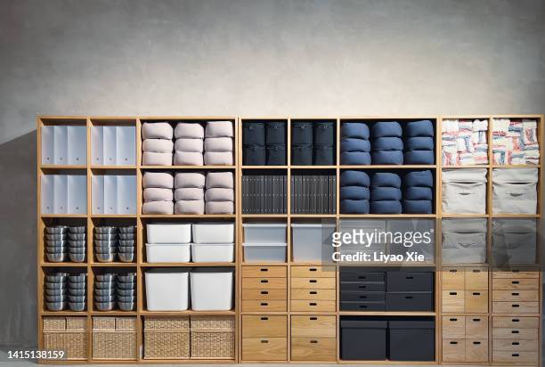 various stuff stacked in wooden wardrobe - ordenado fotografías e imágenes de stock