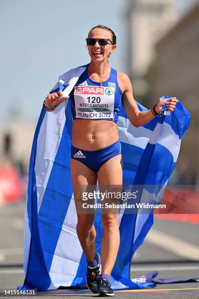 Antigoni Ntrismpioti of Greece celebrates crossing the finish line to win gold during the Athletics Women's 35km Race Walk competition on day 6 of...