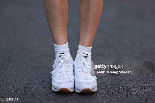 Lea Naumann seen wearing white socks and New Balance x Miu Miu white denim sneaker, on August 14, 2022 in Berlin, Germany.