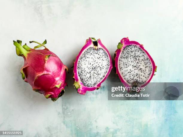 pitaya (dragon fruit) on weathered blue background - fruta de cactus fotografías e imágenes de stock