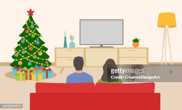 ilustraciones, imágenes clip art, dibujos animados e iconos de stock de sala de estar de navidad con árbol de navidad, cajas de regalo y vista trasera de una joven pareja sentada en el sofá y viendo la televisión - mirar un objeto