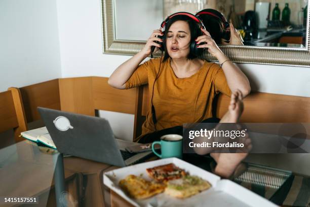a middle-aged woman sitting in the kitchen , unemployed - stress eating stock pictures, royalty-free photos & images