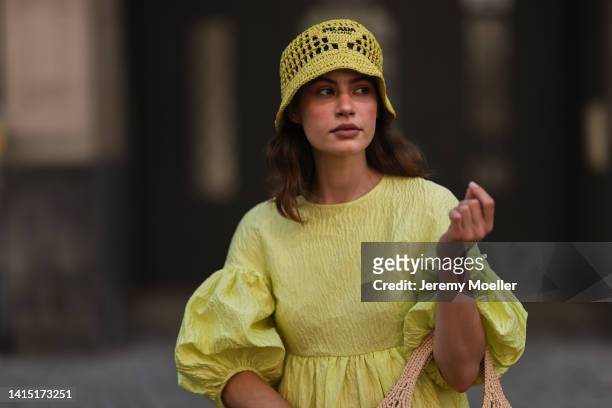 Lea Naumann seen wearing Cecilie Bahnsen neon yellow green long dress with puffer sleeves, Prada neon yellow Raphia bast bucket hat, Prada logo beige...