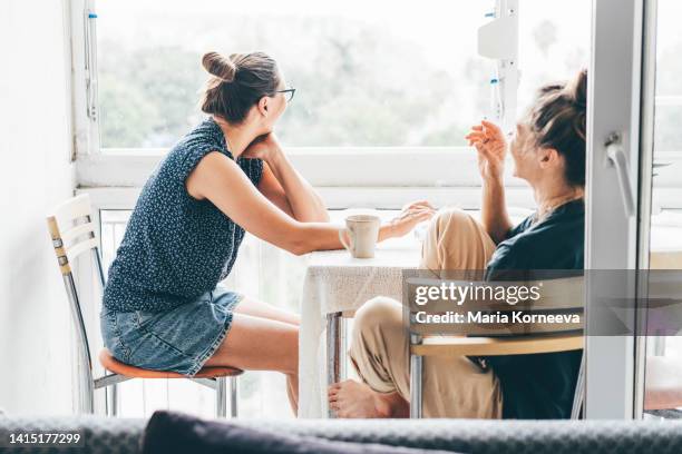 sad girlfriends smoking at the balcony - woman smoking stock pictures, royalty-free photos & images