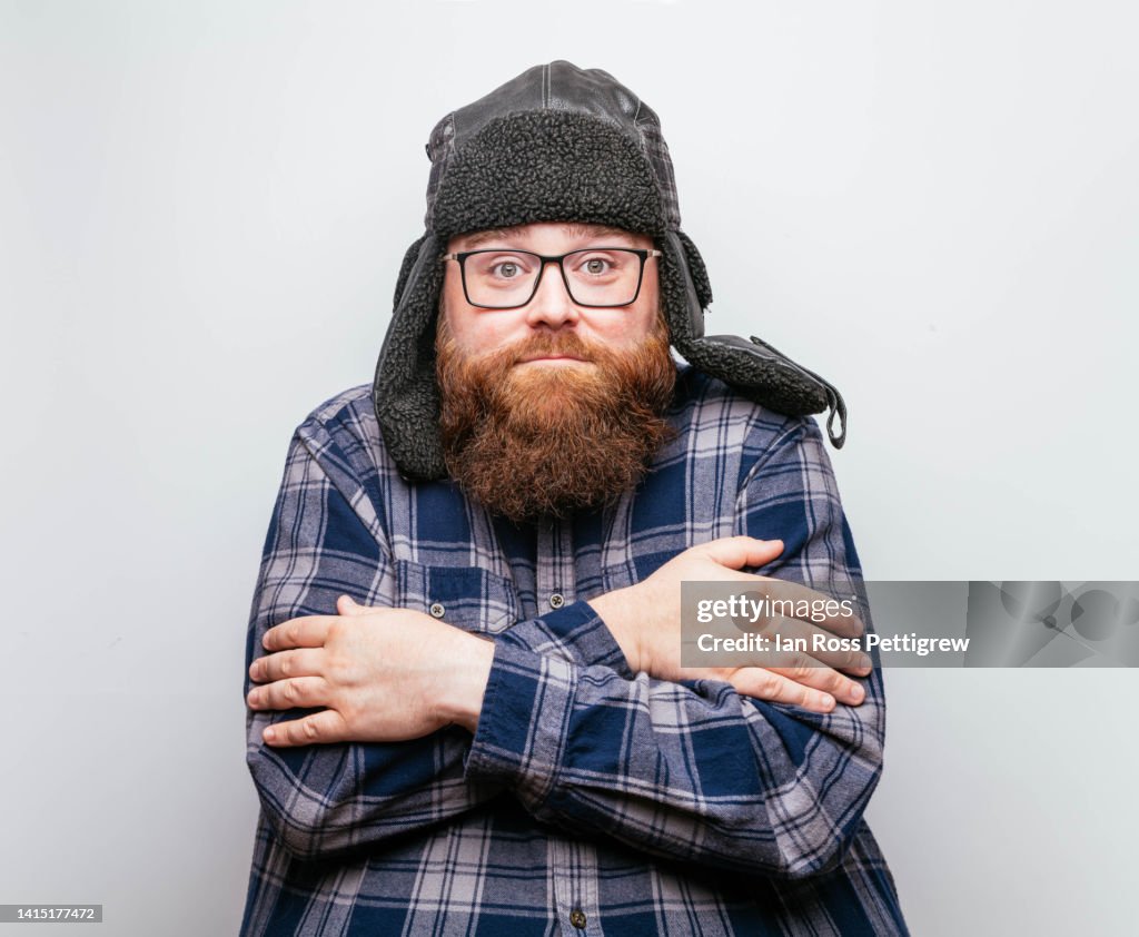 Bearded man wearing winter hat and plaid shirt