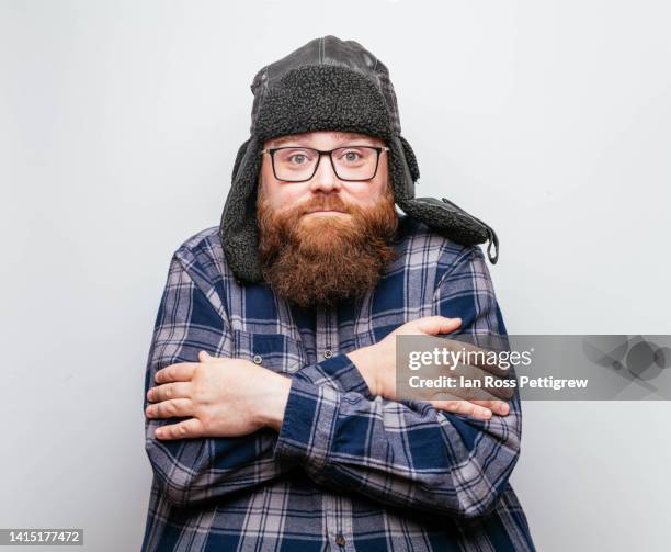bearded man wearing winter hat and plaid shirt - shaking stock pictures, royalty-free photos & images