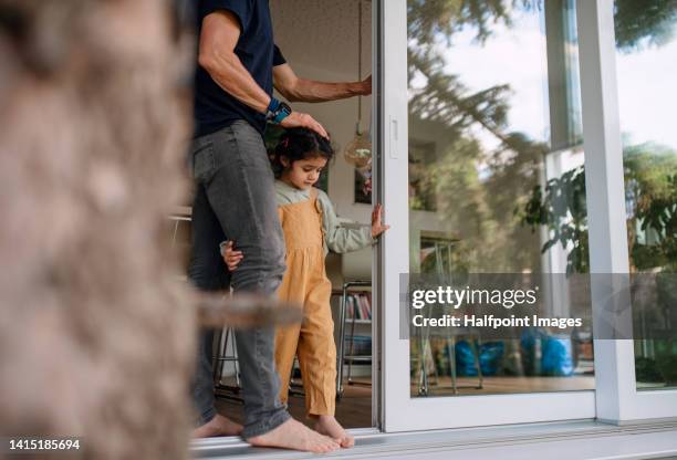 little multiracial girl walking in balcony window with her father. - modern apartment balcony stockfoto's en -beelden