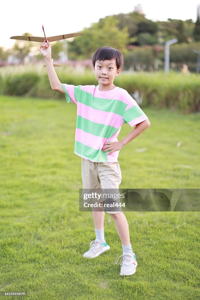 Niño jugando con aviones de juguete en el parque