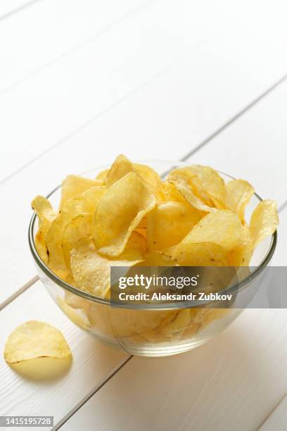 crispy fried potato chips with fat in a glass bowl or plate on a white wooden background or table. the concept of unhealthy diet and lifestyle, the accumulation of excess weight. overeating. - lunch bag white background stock pictures, royalty-free photos & images