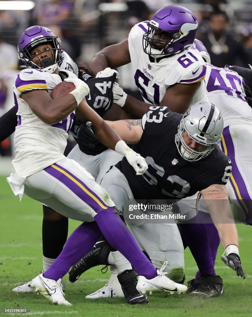 Running back Ty Chandler of the Minnesota Vikings avoids a tackle