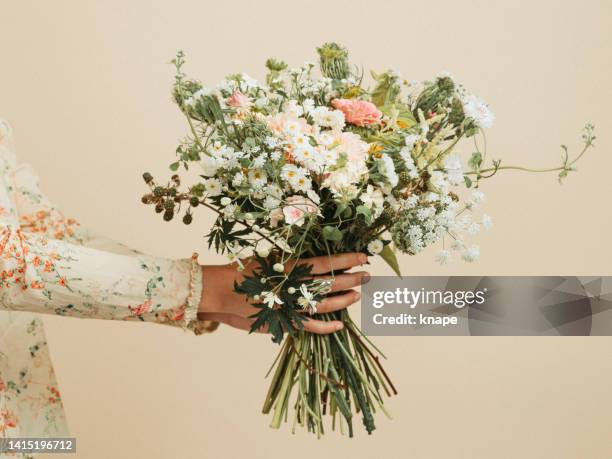 femme tenant un bouquet de fleurs au pastel - bouquet photos et images de collection