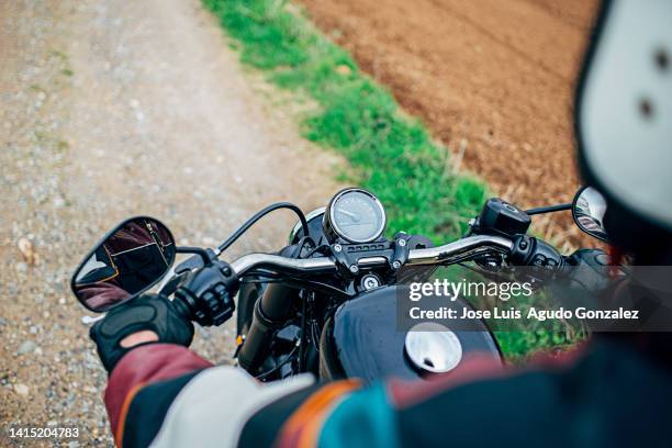 biker rides his motorcycle on a country road in winter - manubrio foto e immagini stock