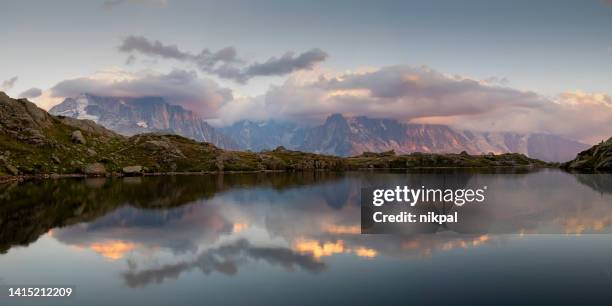 the mont blanc massif reflection into cheserys lake at sunset - france - lake chesery stockfoto's en -beelden