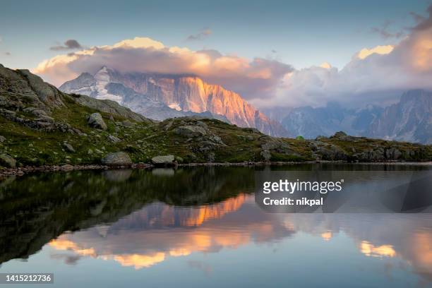 the grand jorasses reflection into cheserys lake at sunset - france - lake chesery stockfoto's en -beelden
