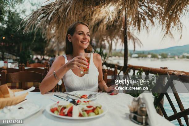 woman drinking ice tea in a restaurant at the seaside in greece - beach bowl stock pictures, royalty-free photos & images