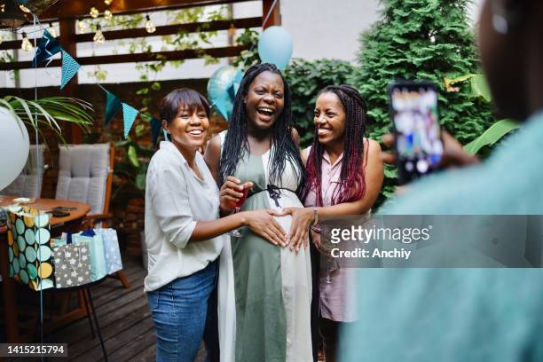 group of women taking photos during a baby shower - babyshower stockfoto's en -beelden
