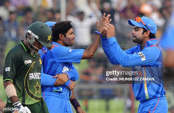 Indian cricketer Virat Kholi congratulates teammate Ashok Dinda after the dismissal of Pakistan's Mohammad Hafeez during the one day international...
