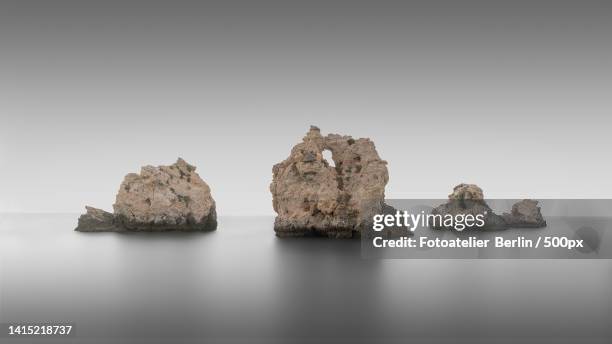 panoramic view of rocks in sea against clear sky,sesmarias,albufeira,portugal - felsenküste stock pictures, royalty-free photos & images