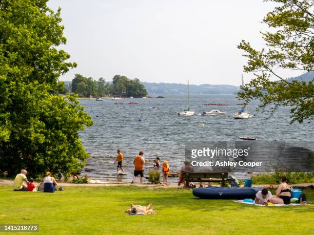 crowds cool off in lake windermere in the mid july 2022 heatwave, when temperature records were smashed across the uk, and the lake district saw record temperatures of 32 degrees. - lake windermere stock-fotos und bilder