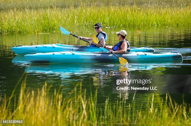 Austin Brodmerkel and Theresa Travers, both of West Islip paddle their kayaks in Stony Brook Harbor, in Stony Brook, New York, on August 15, 2022.