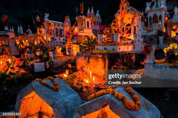 Tombs and graves, decorated with marigold flowers, are seen illuminated by burning candles during the Day of the Dead celebration at the cemetery on...