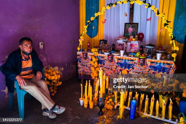 Mexican man sits in front of an altar of the dead , a religious site honoring the deceased, during the Day of the Dead celebrations on November 2,...